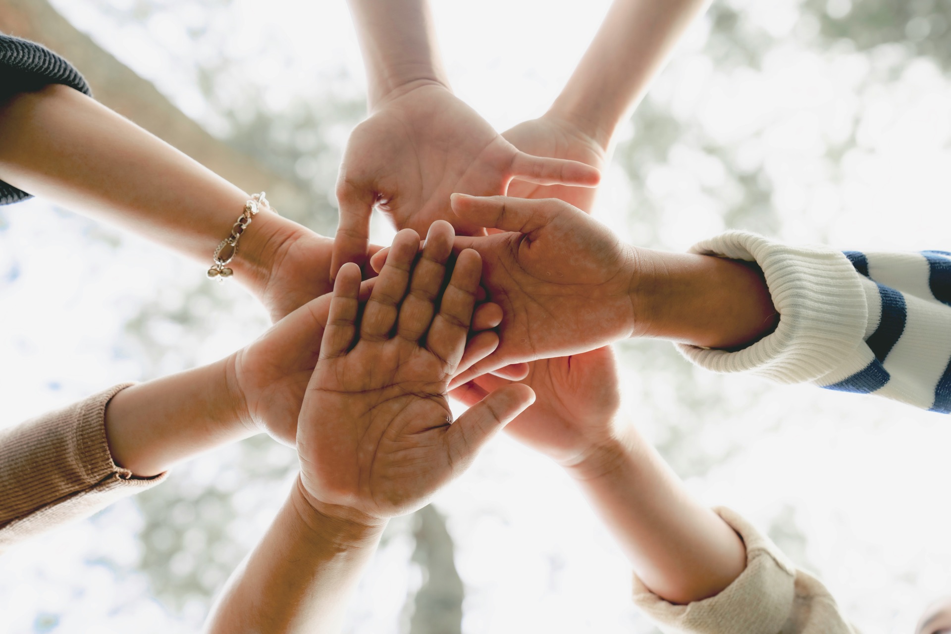 Multiple hands stacked together in a circular formation